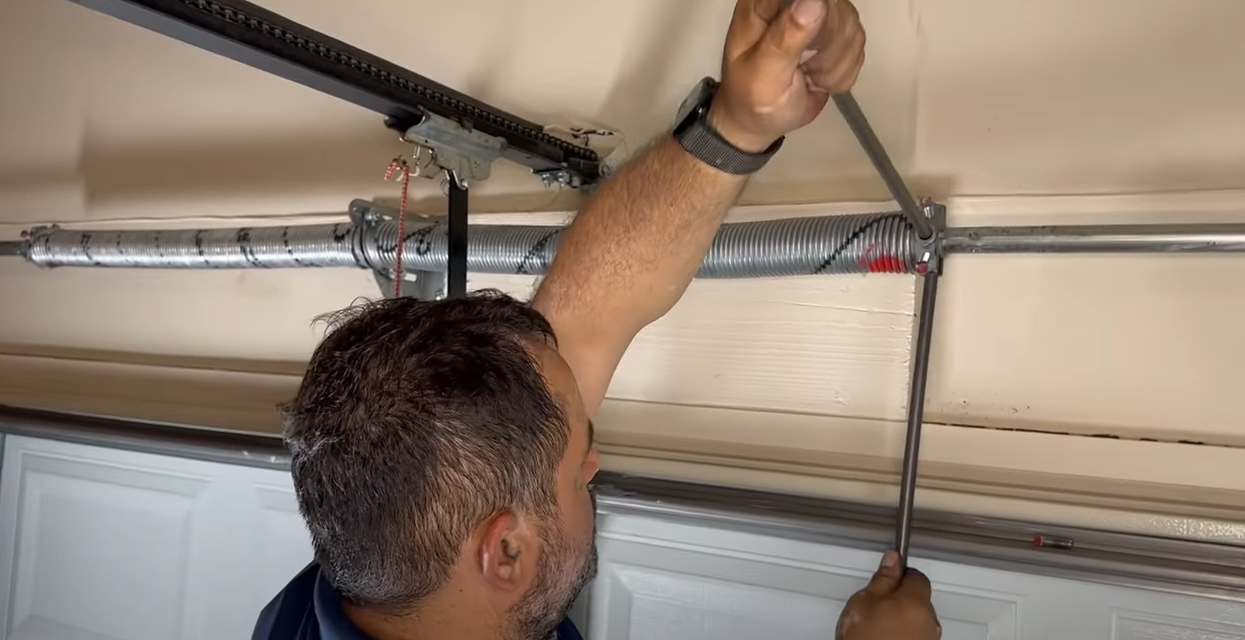 A professional technician repairing a garage door spring in Sarasota, FL, showcasing expert garage door spring repair services.