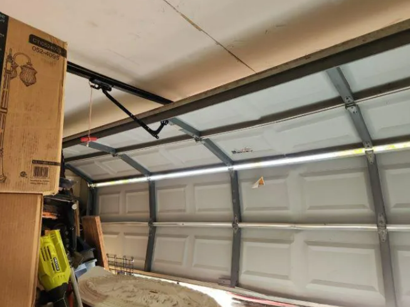 Technician repairing an overhead garage door in Sarasota, FL for Local Garage Door Repair Services.