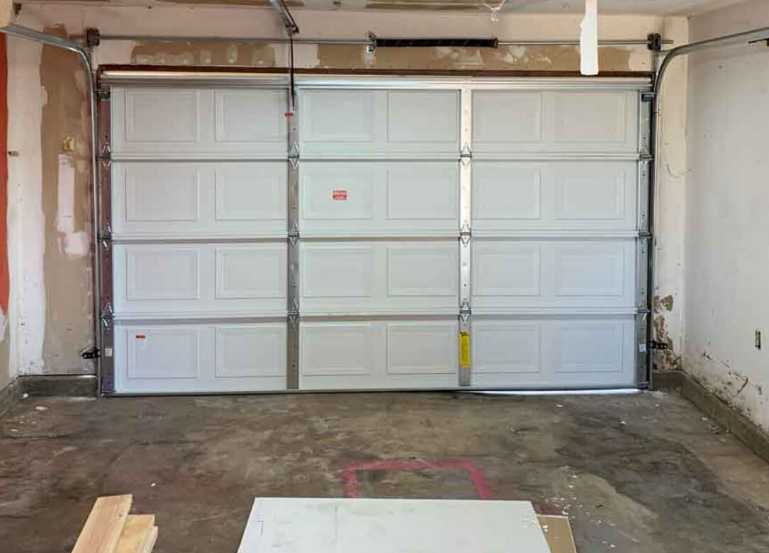 Image of a technician performing garage door section replacement in Sarasota, FL, showcasing professional local garage door repair services.
